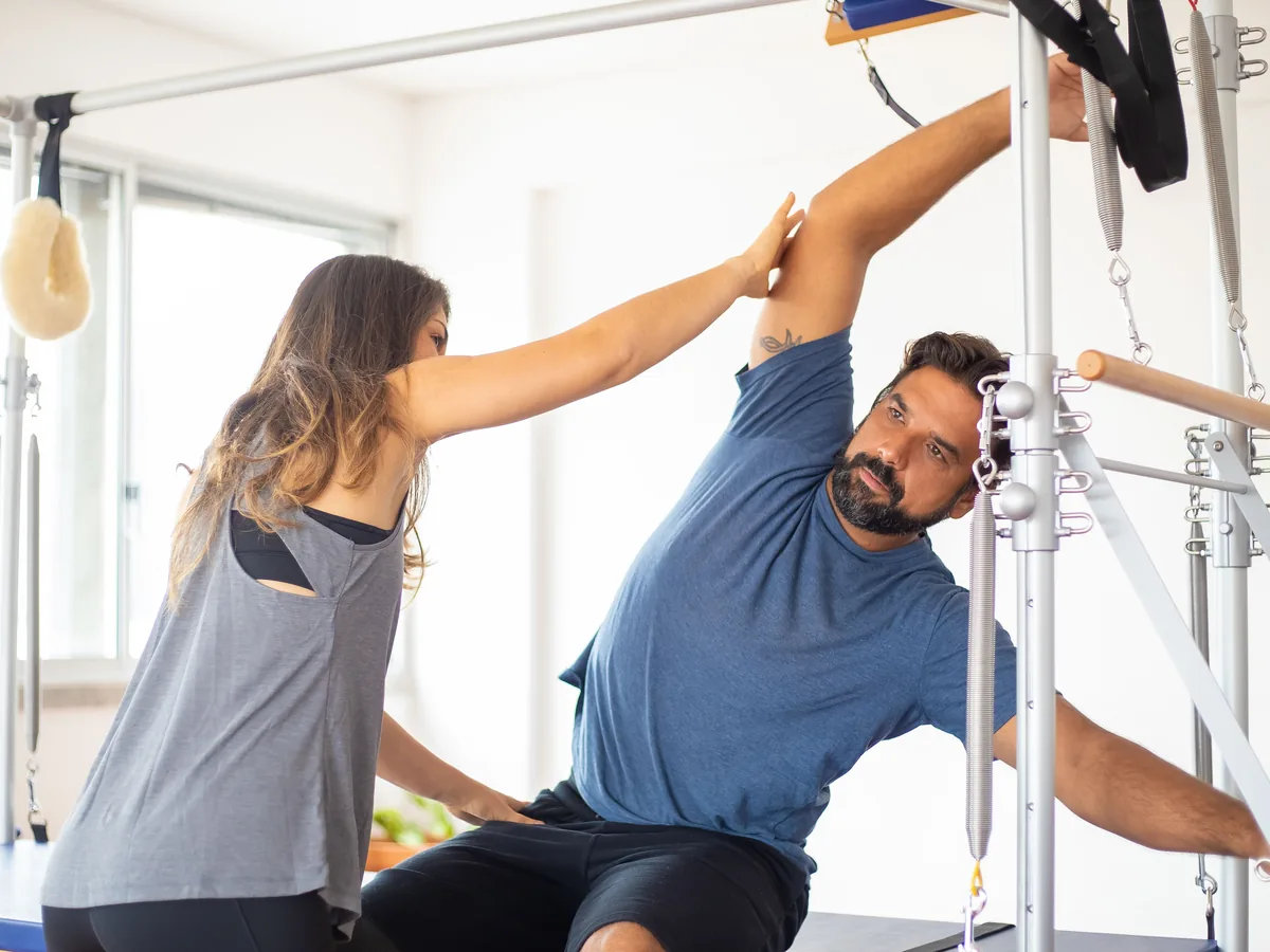 A teacher guiding a client through a reformer sequence